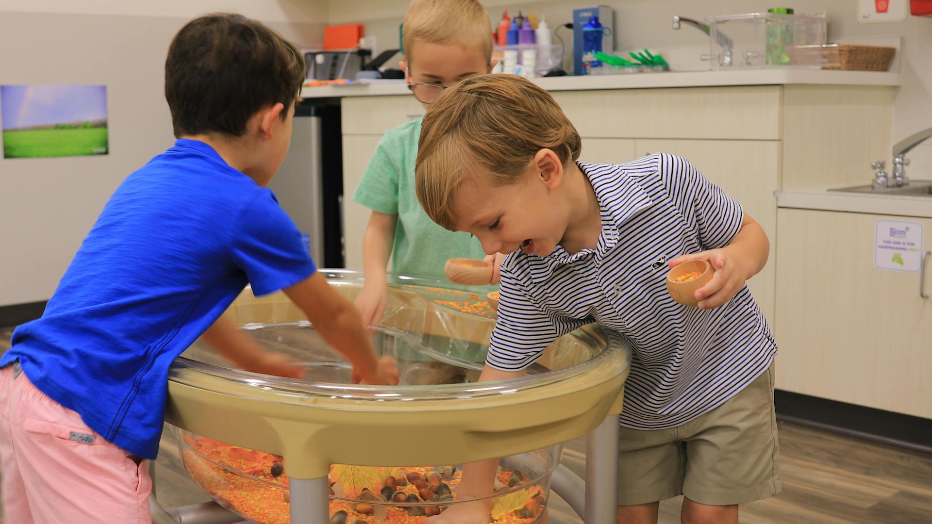 Three children playing at a water table