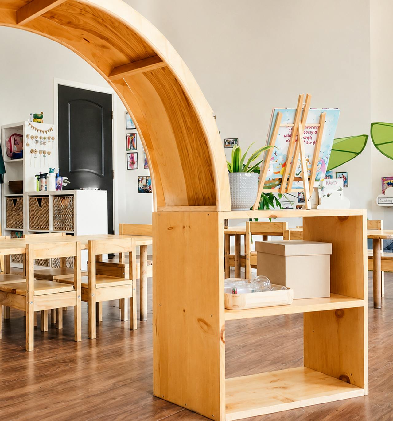Wooden arch display shelf in a classroom with small chairs and tables