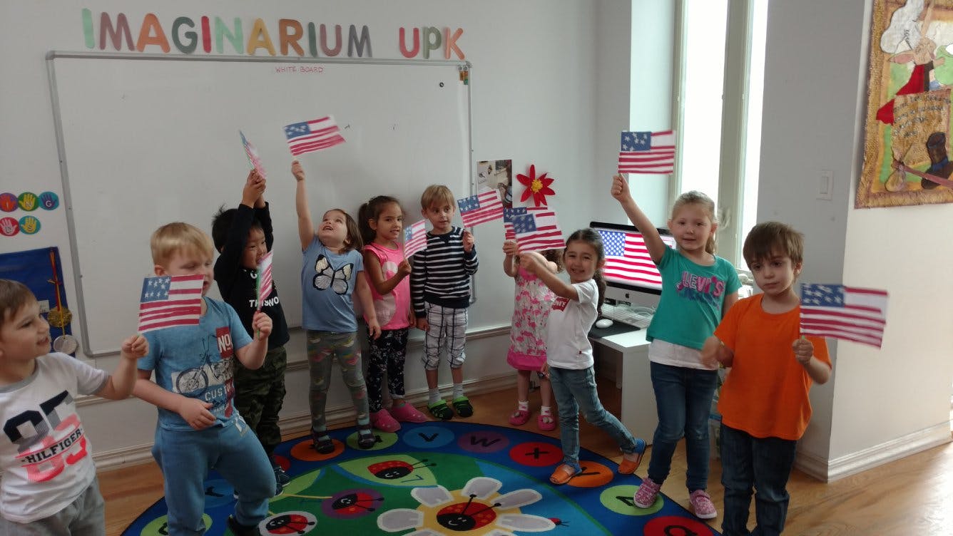 Children holding small American flags in a classroom