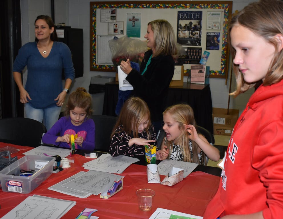 Adults and children at a table with craft supplies