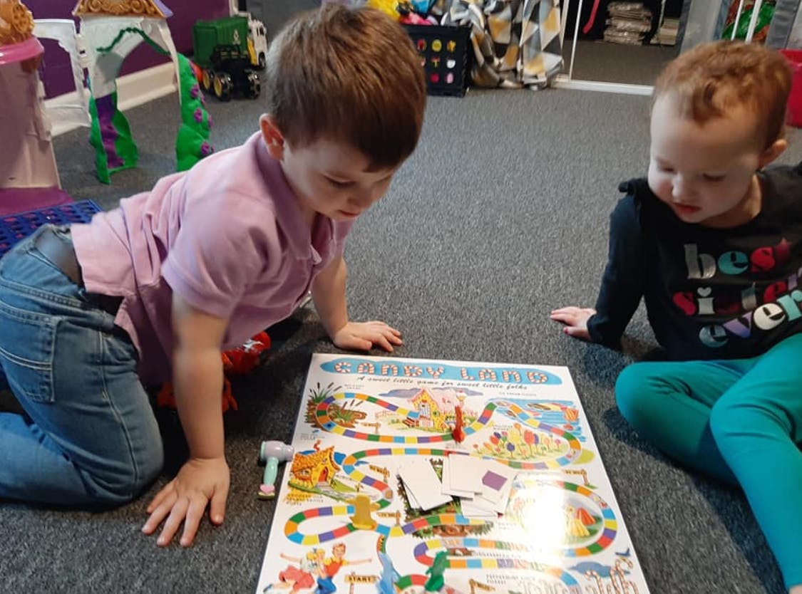 Two children playing a board game on the floor