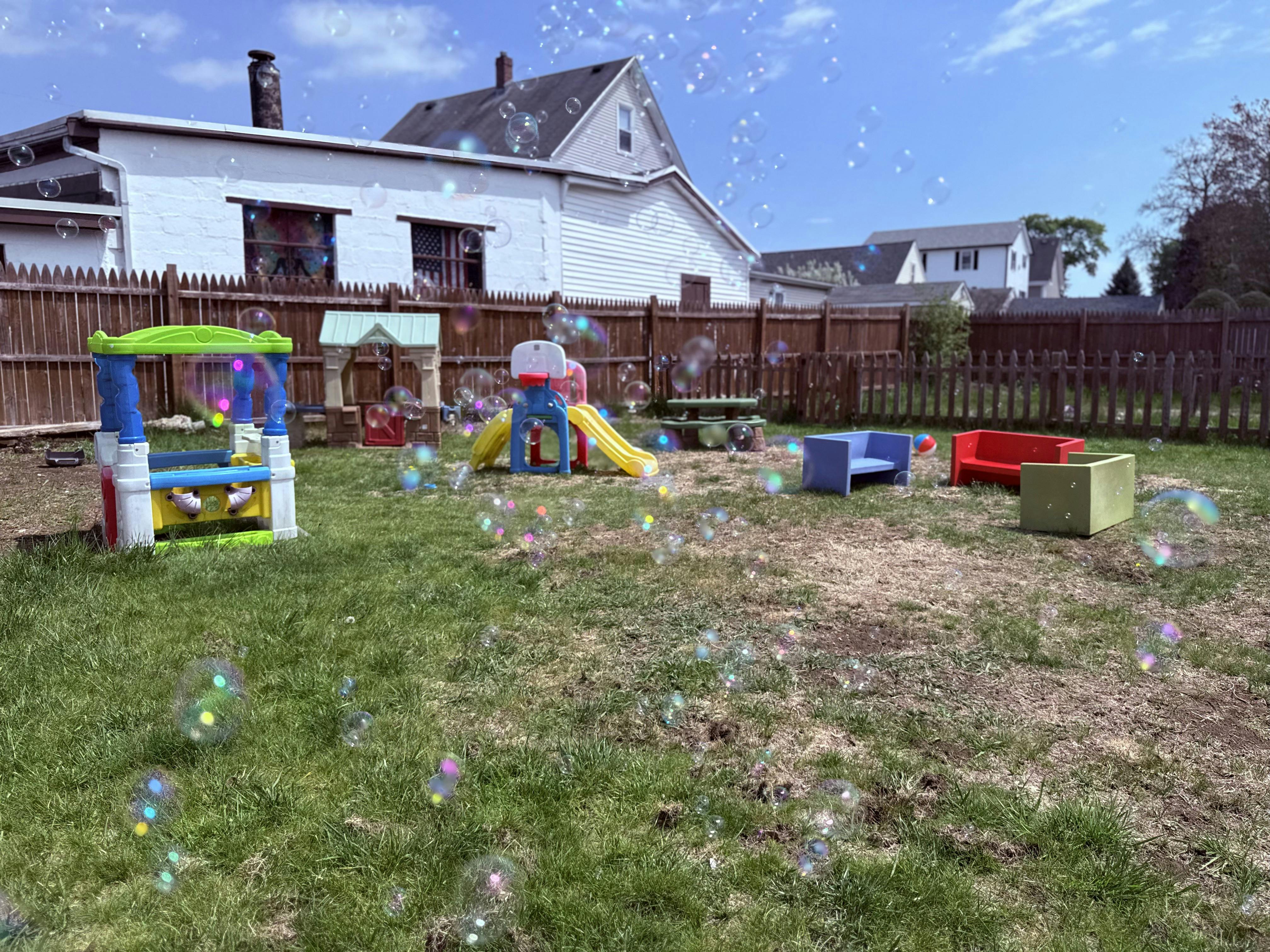 Floating soap bubbles over a backyard playground