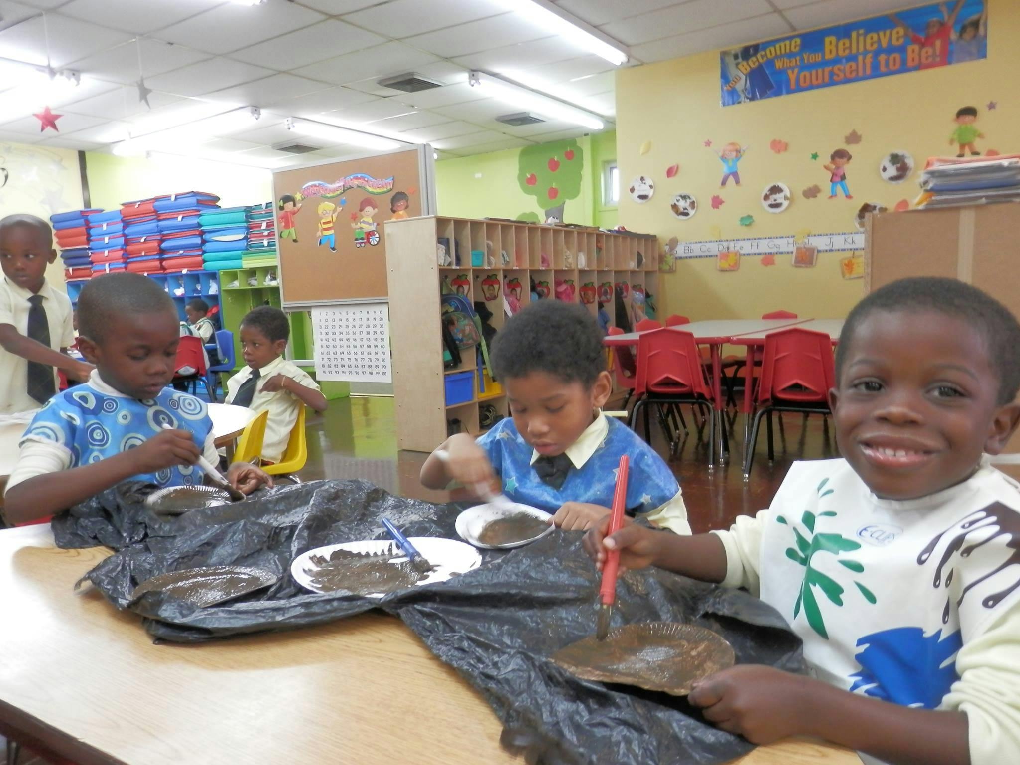Children doing an art activity at a table in a classroom