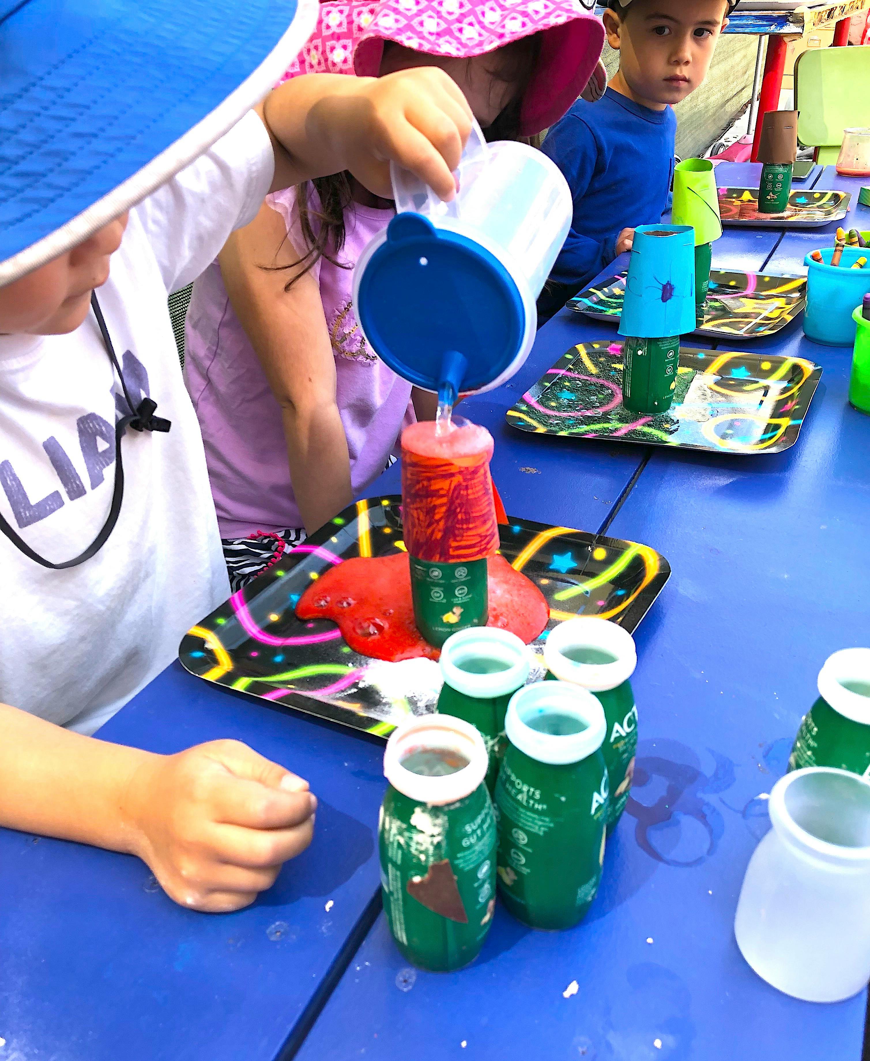 Child pouring liquid into a container, creating a foamy red overflow