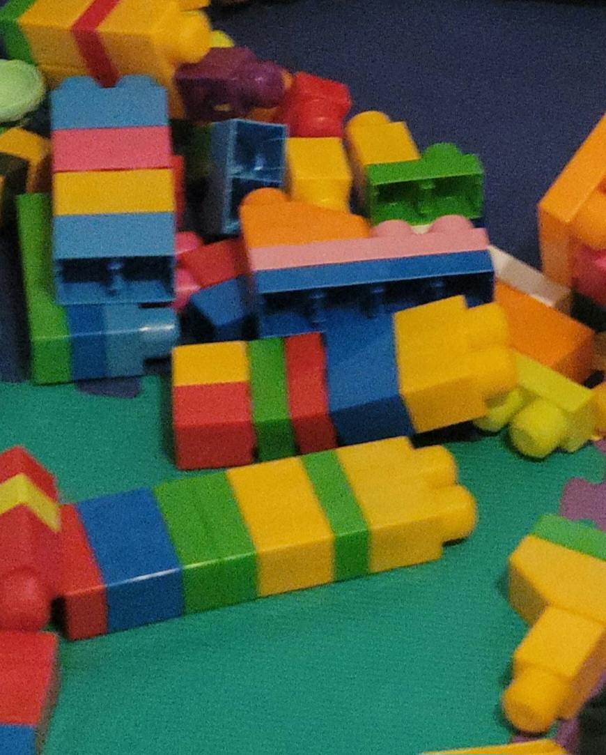 Pile of assorted colorful plastic building blocks on a play mat