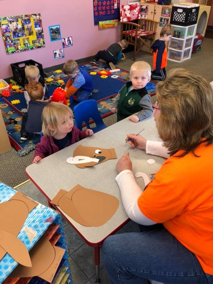 Adult and children doing crafts at a table