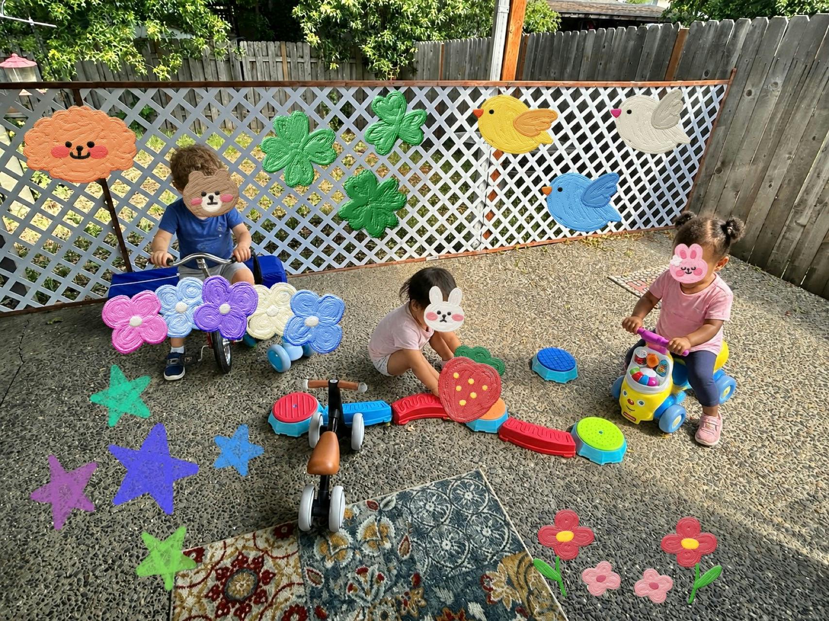 Three children playing with ride-on toys and building blocks in a backyard