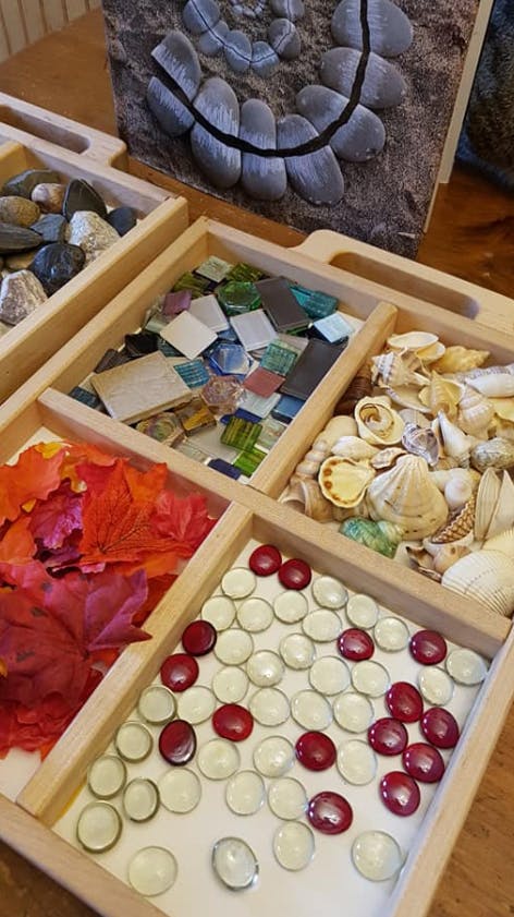 Wooden tray with compartments holding various craft supplies