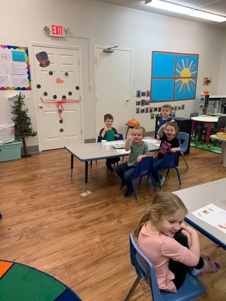 Children sitting at tables in a classroom