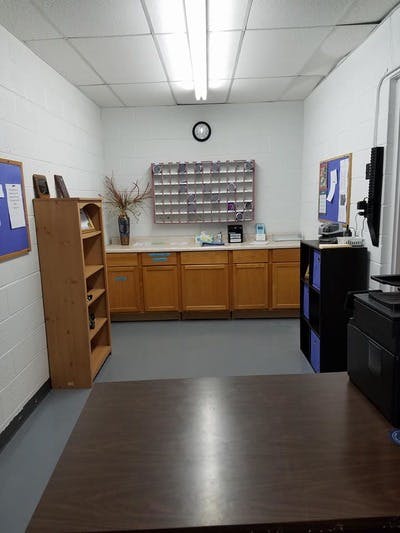 Room with wooden cabinets, a bookshelf, and a large table