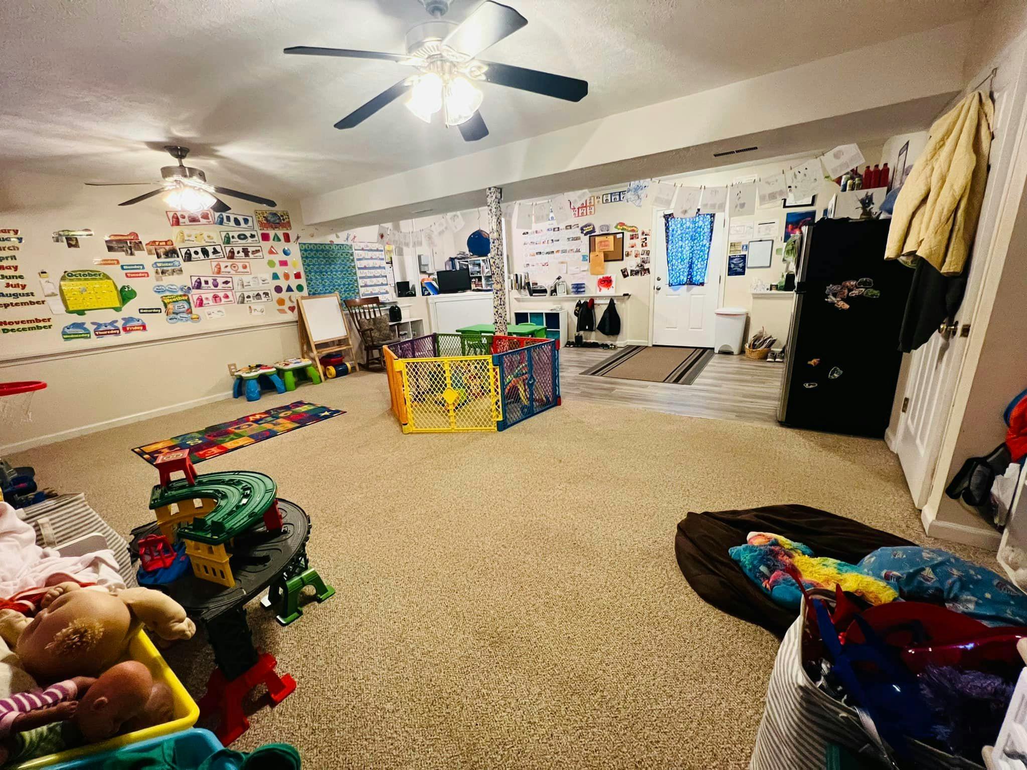 Playroom with toys, playpen, and educational posters on the walls