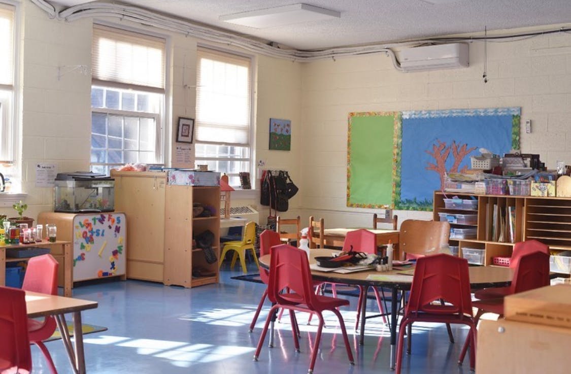 Classroom with small tables and red chairs