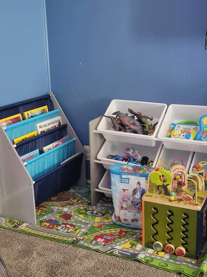 Children's room with toy storage, books, and play mat