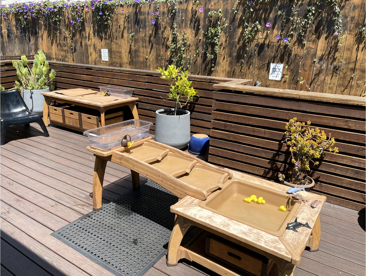 Outdoor play area with wooden water tables and plants