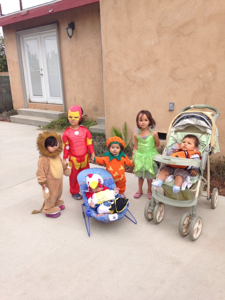 Children in costumes, one in a lion costume, one in Iron Man, one in a pumpkin