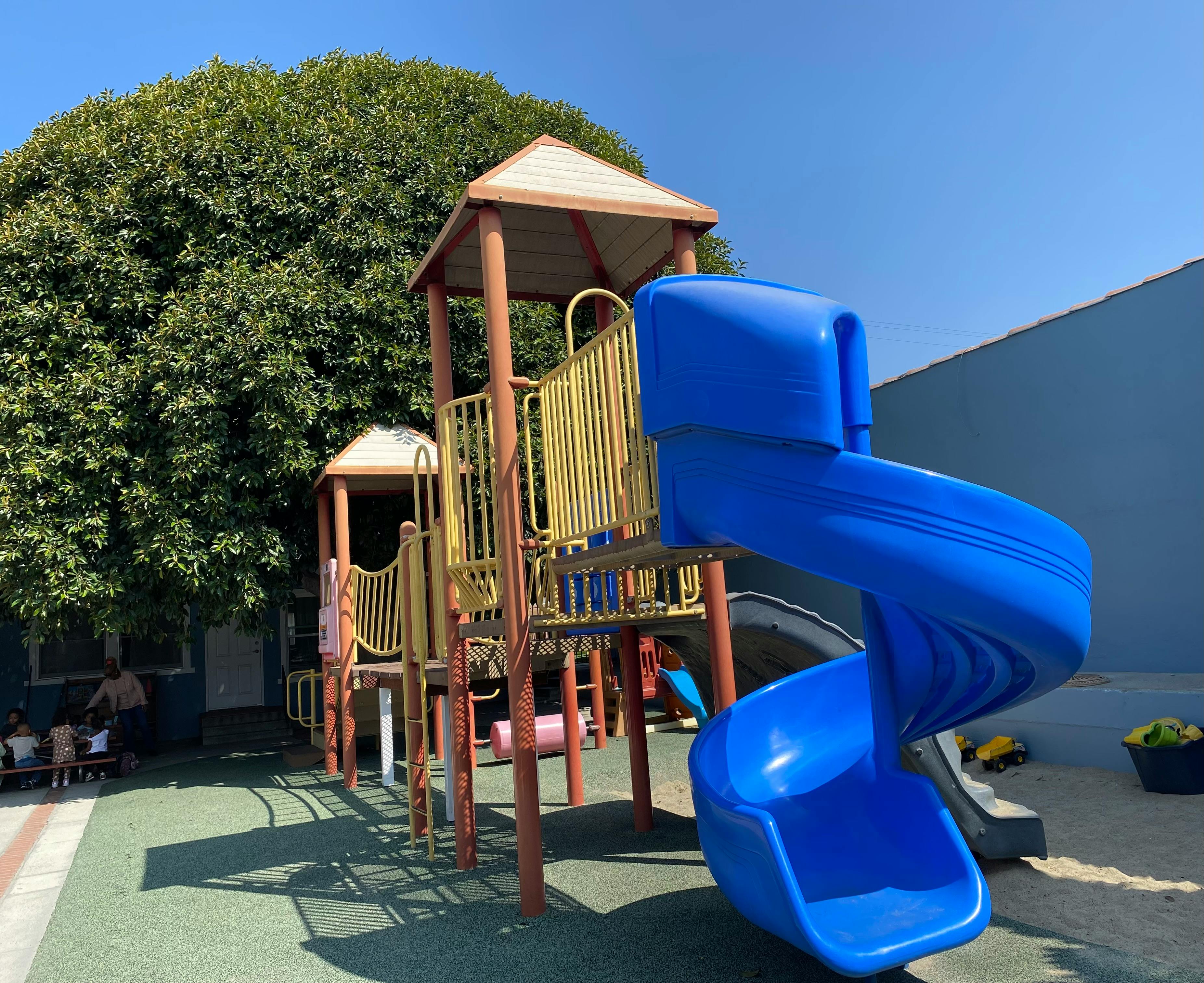Playground structure with a blue spiral slide