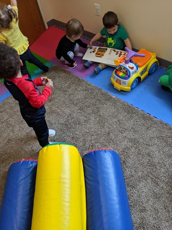 Children playing with toys on a colorful mat
