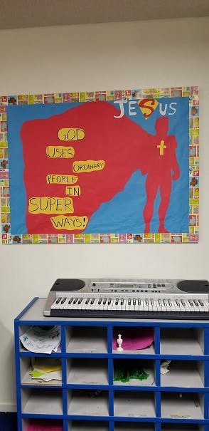 Bulletin board with superhero figure and text about God and people