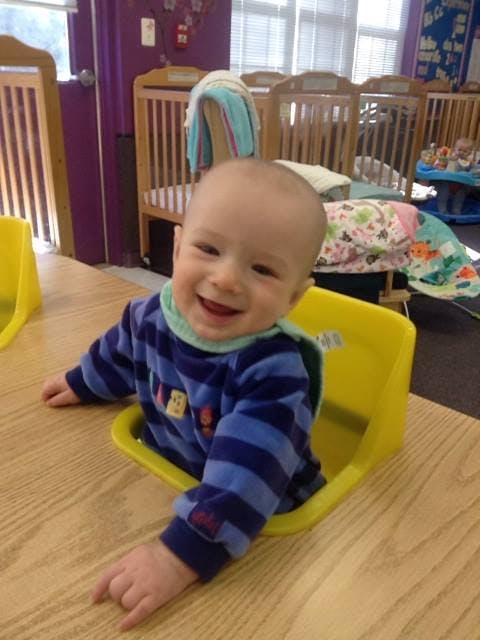 Child in a yellow high chair at a table