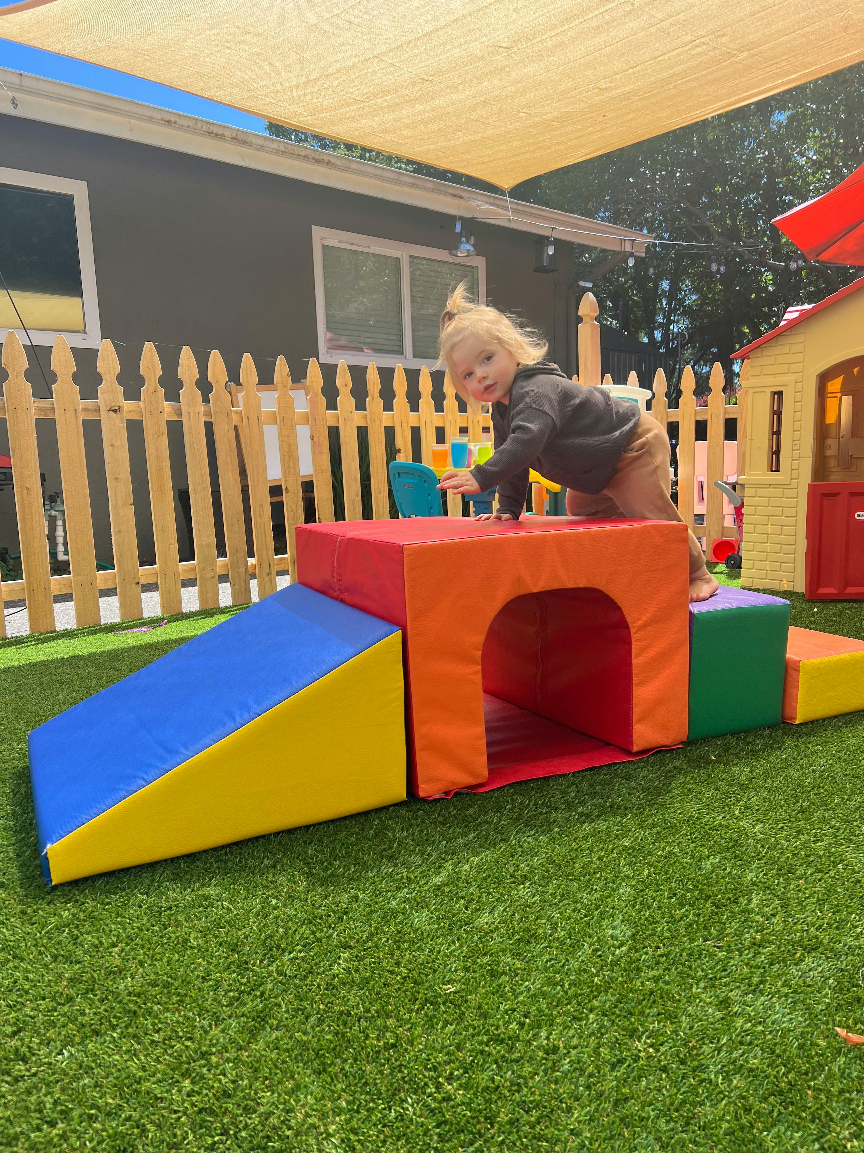 Child crawling on colorful soft play equipment