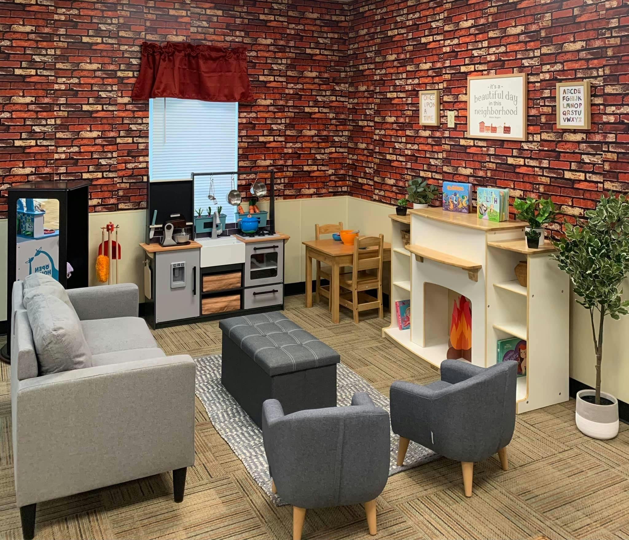 Playroom with toy kitchen, small table and chairs, and seating area