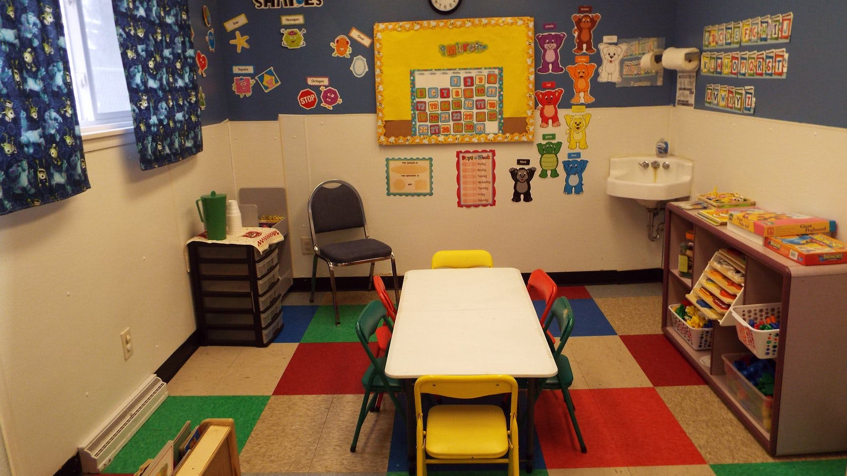 Child's classroom with small table and chairs, sink, and colorful floor