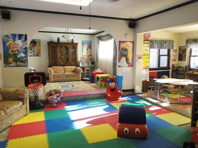 Playroom with colorful floor mats, couches, and children's toys