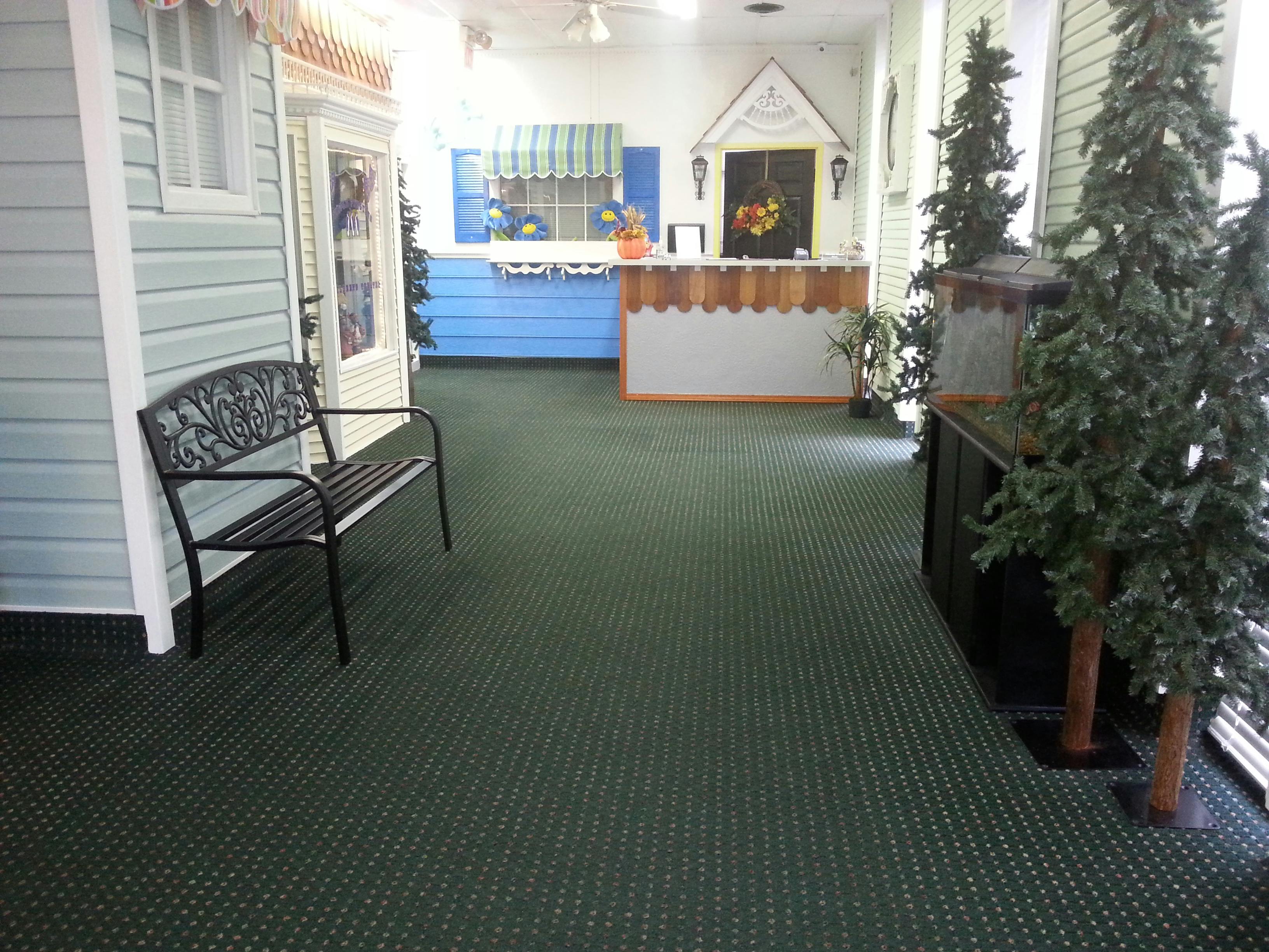 Indoor area with a bench, miniature house facade, and reception desk