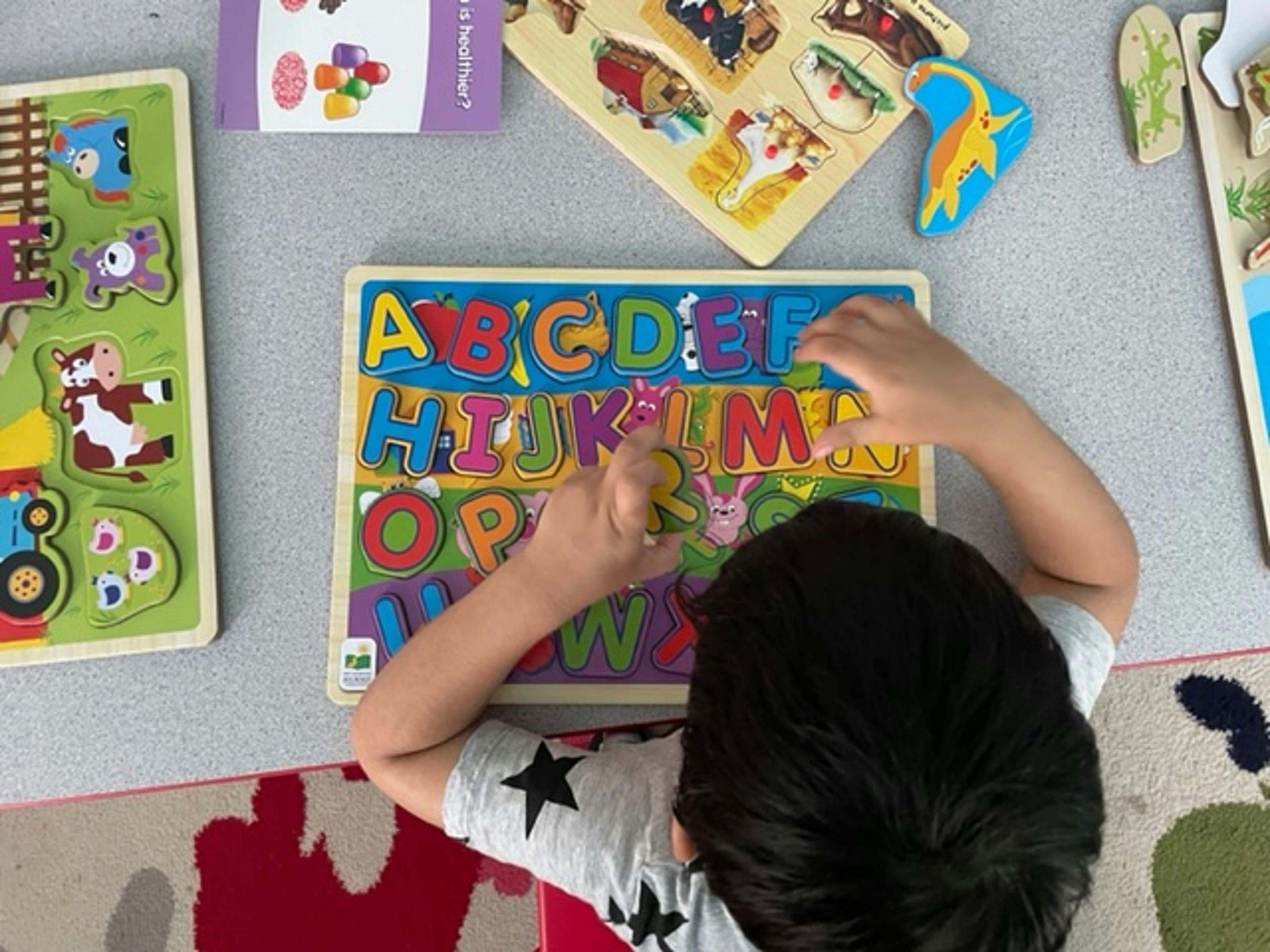 Child playing with an alphabet puzzle