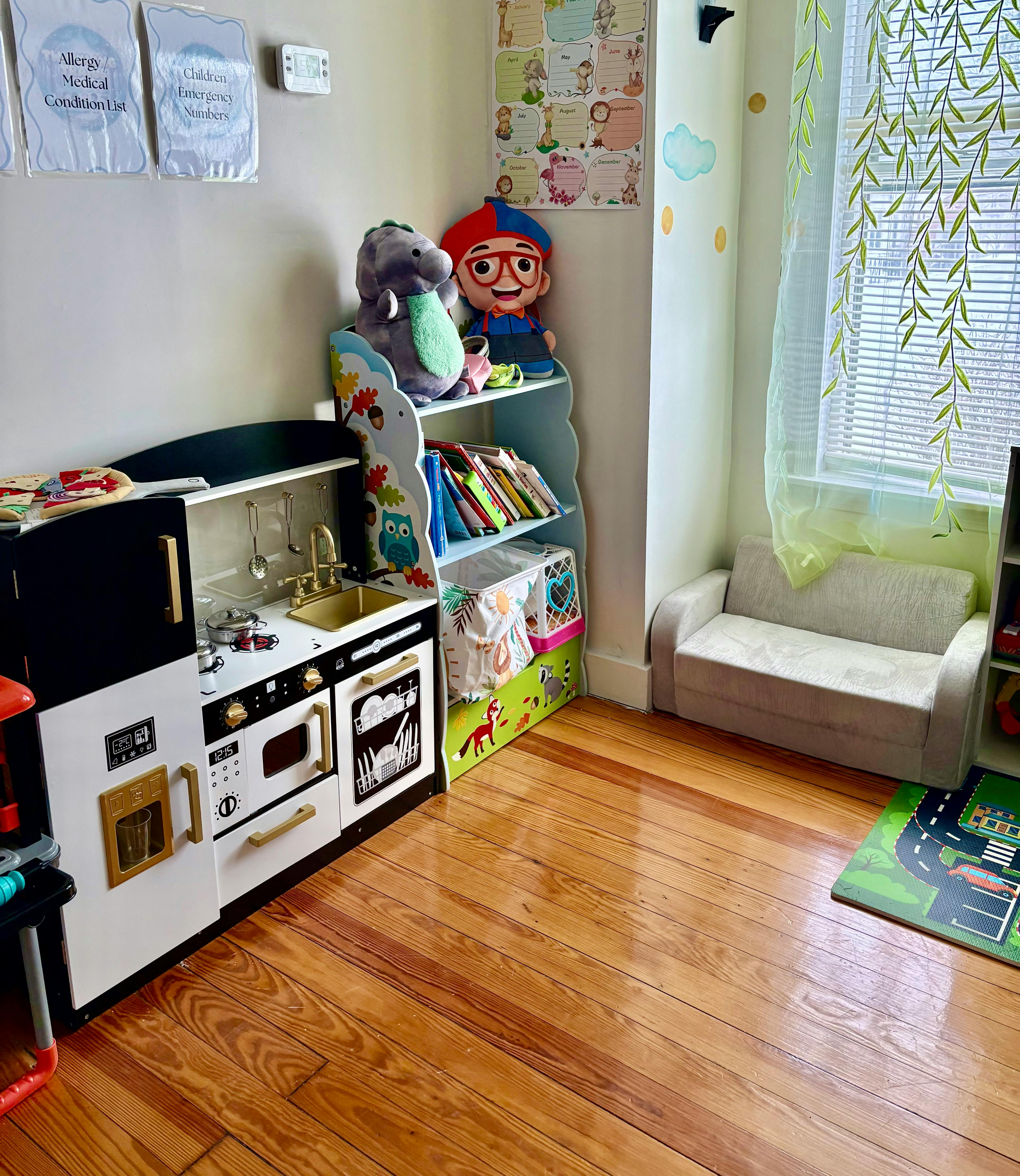 Children's playroom with a play kitchen, toy shelf, and small couch