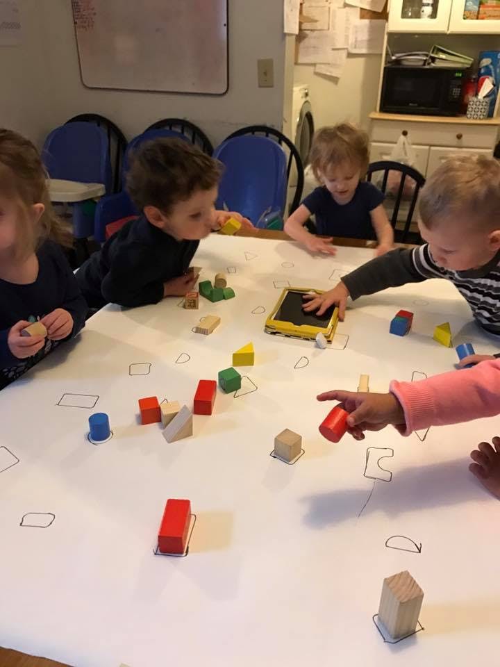 Children playing with colorful building blocks on a table