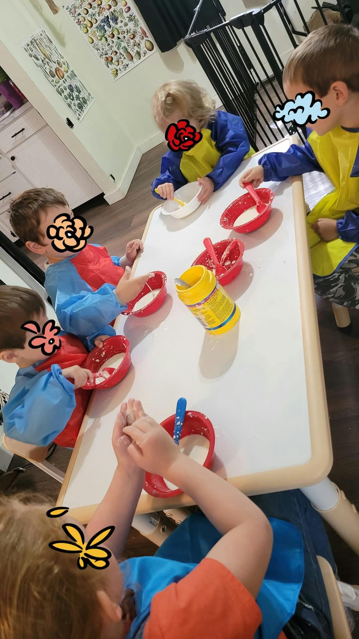 Children at a table with bowls and spoons