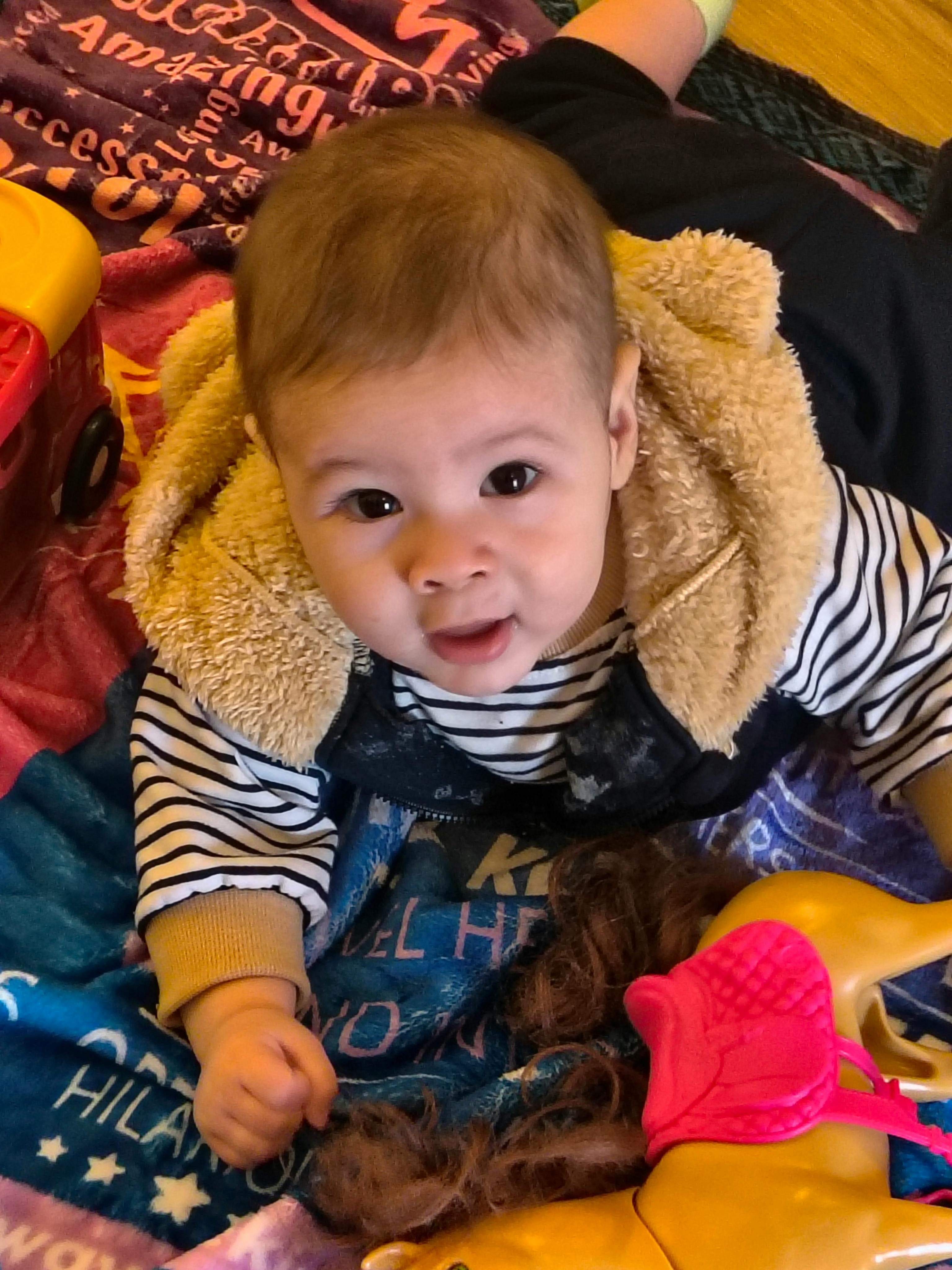 Child wearing a striped shirt and a fuzzy vest