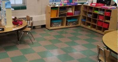 Classroom with checkered floor, tables, chairs, and storage shelves