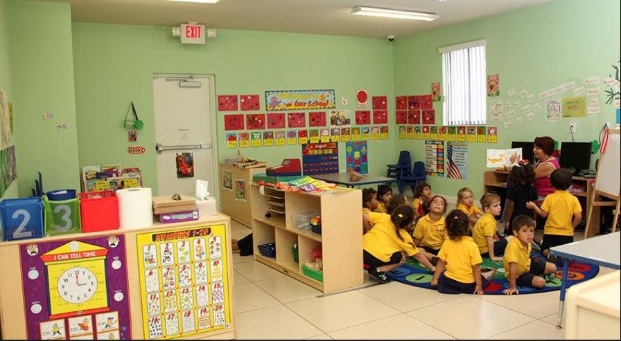 Children sitting on a rug in a classroom