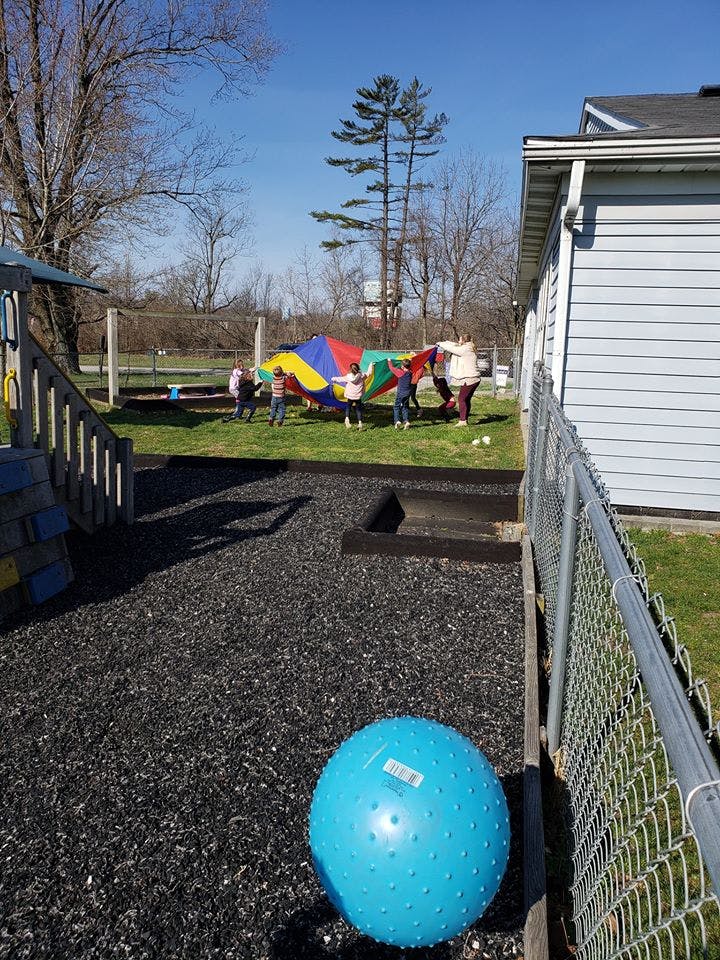 Children playing with a colorful parachute on a grassy field