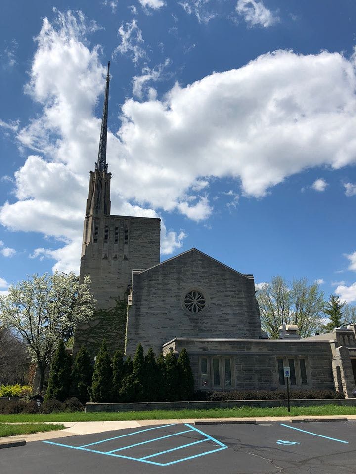 Stone building with a tall steeple and a circular window