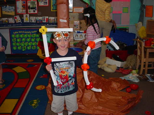 Child holding two large construction toy pieces