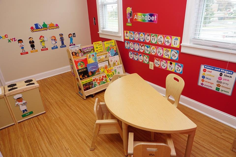 Classroom with small table and chairs, book display, and alphabet on wall