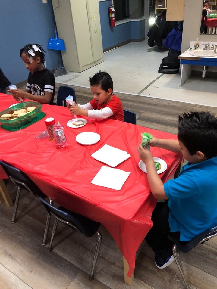 Children decorating cookies at a table