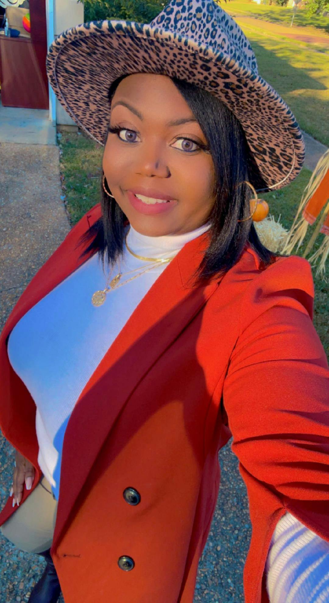Person wearing a leopard print hat and a red blazer