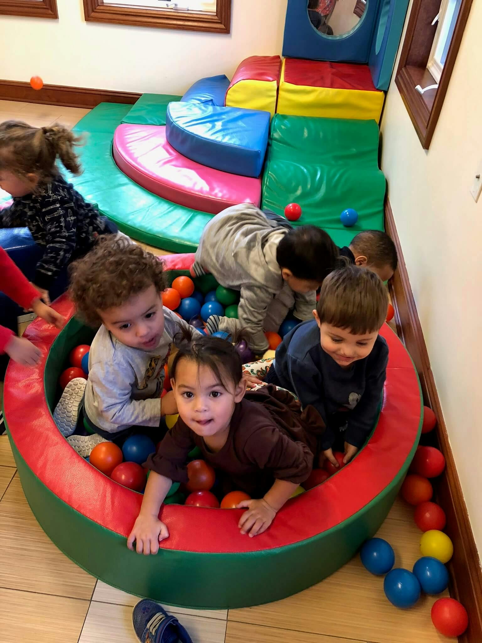 Children playing in a ball pit and soft play area