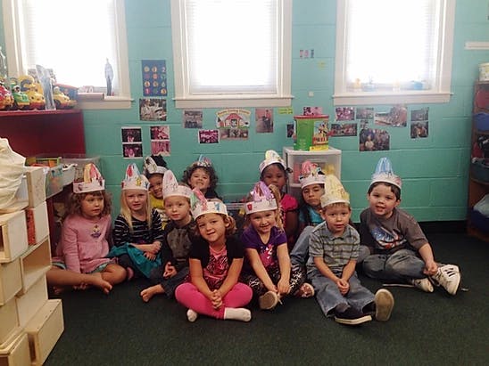 Group of children wearing party hats sitting on the floor