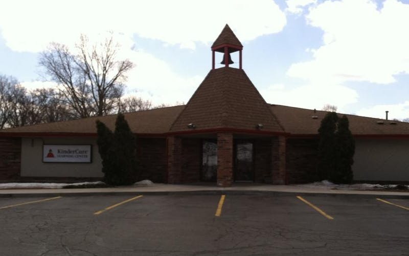 KinderCare Learning Center building with bell tower and empty parking lot
