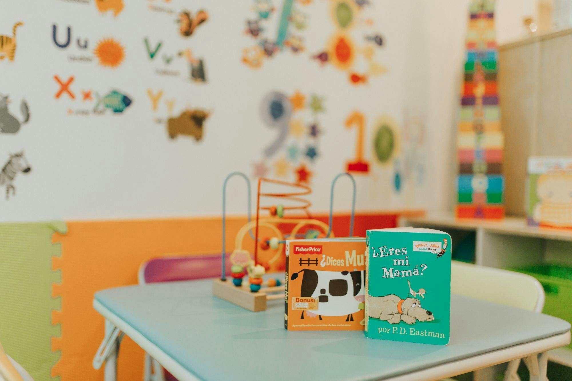Two children's books and a toy on a table in a classroom