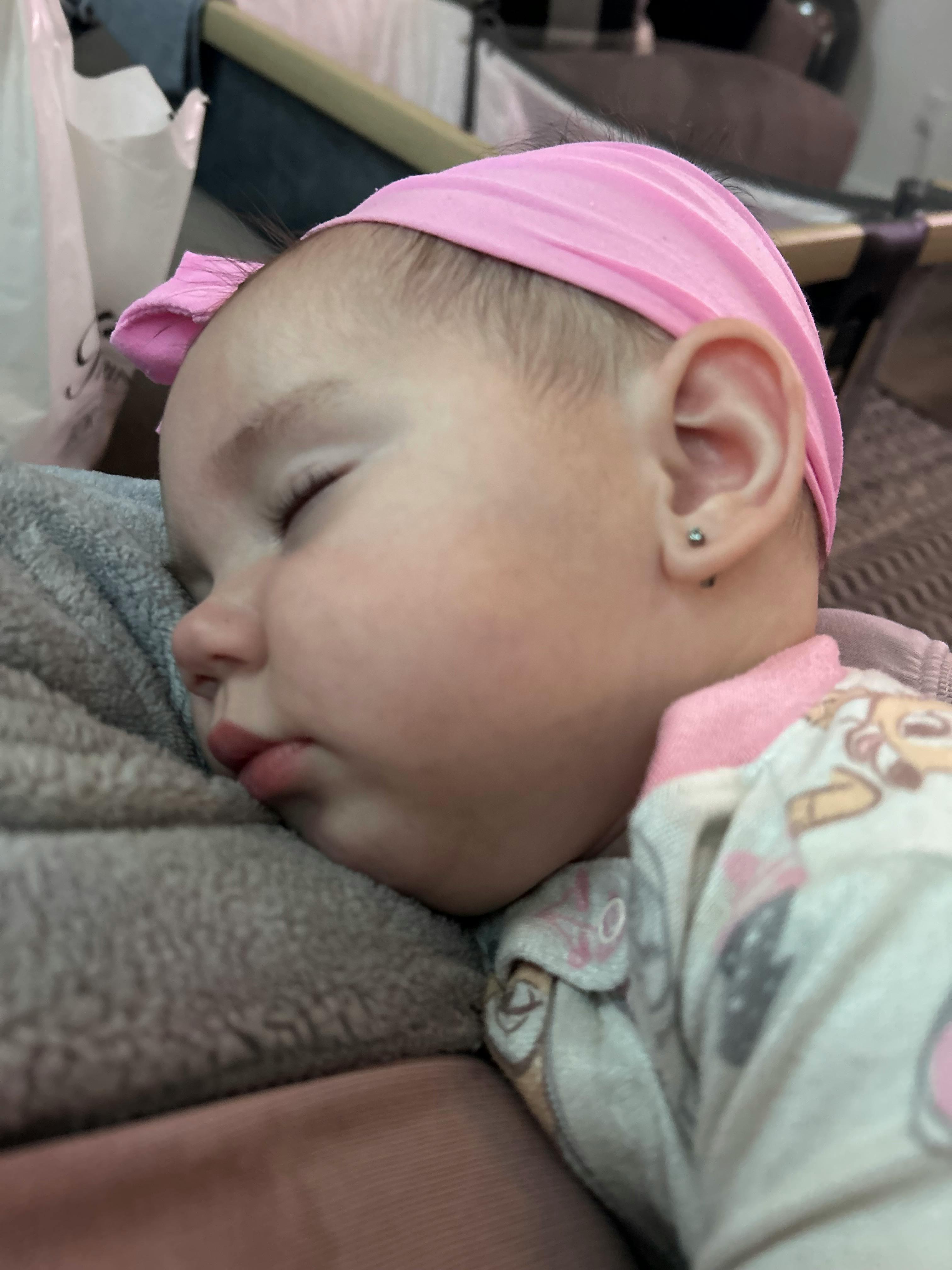 Child sleeping with a pink headband