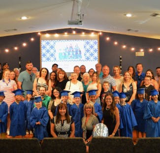 Group of people and children in graduation caps and gowns