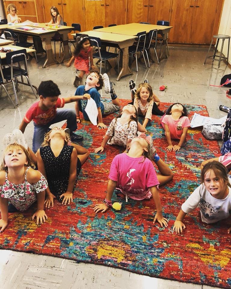 Children lying on a rug, looking up