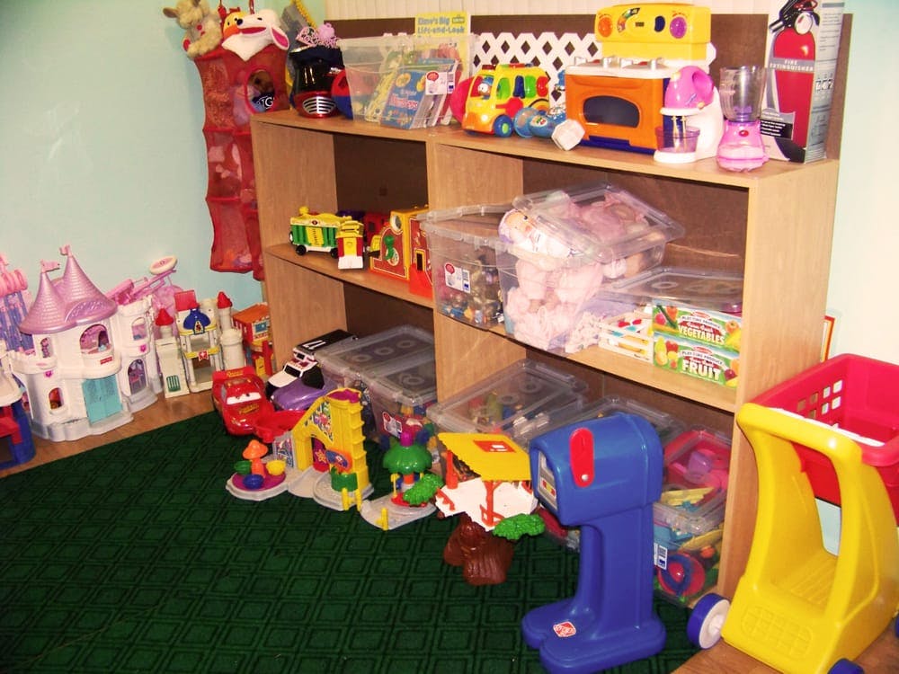 Shelves and floor filled with various toys in a play area