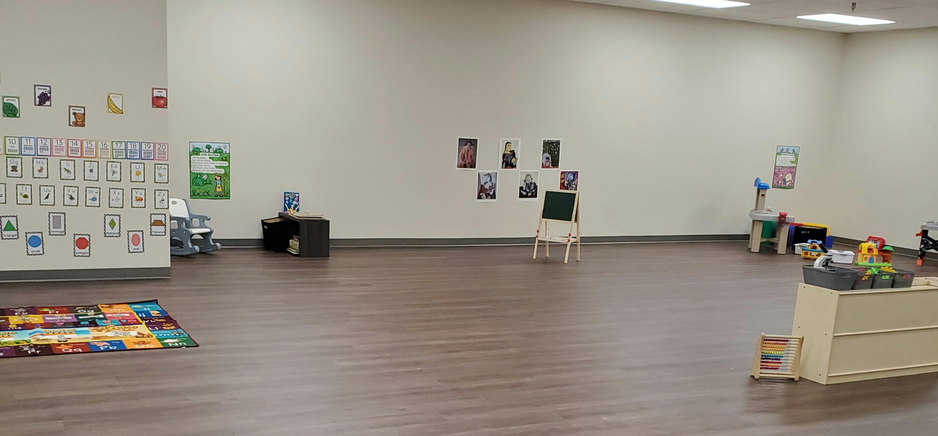 Empty classroom with learning materials on walls and floor